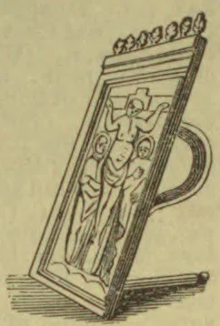 An ornate standing mirror with a decorative frame showing a human figure in relief.