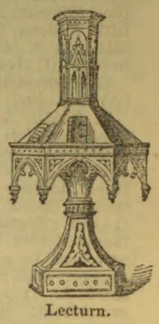 An ornate Gothic-style lectern with a sloped reading desk and decorative pedestal.