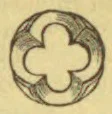 A decorative quatrefoil ornament with a four-lobed central shape.