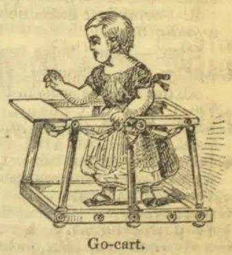 A child stands in a wheeled go-cart frame.