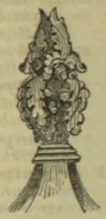 An ornate cluster of carved leaves and flowers rises from a stepped pedestal, with long decorative sprays extending downward on both sides.