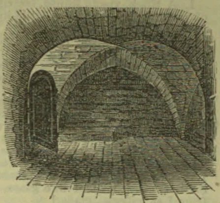 A brick-vaulted chamber with a tiled floor and a small arched doorway in the left wall.